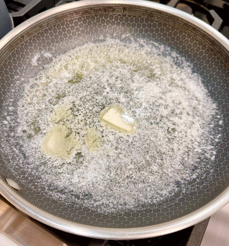 Melting the butter in a large skillet over stove top.