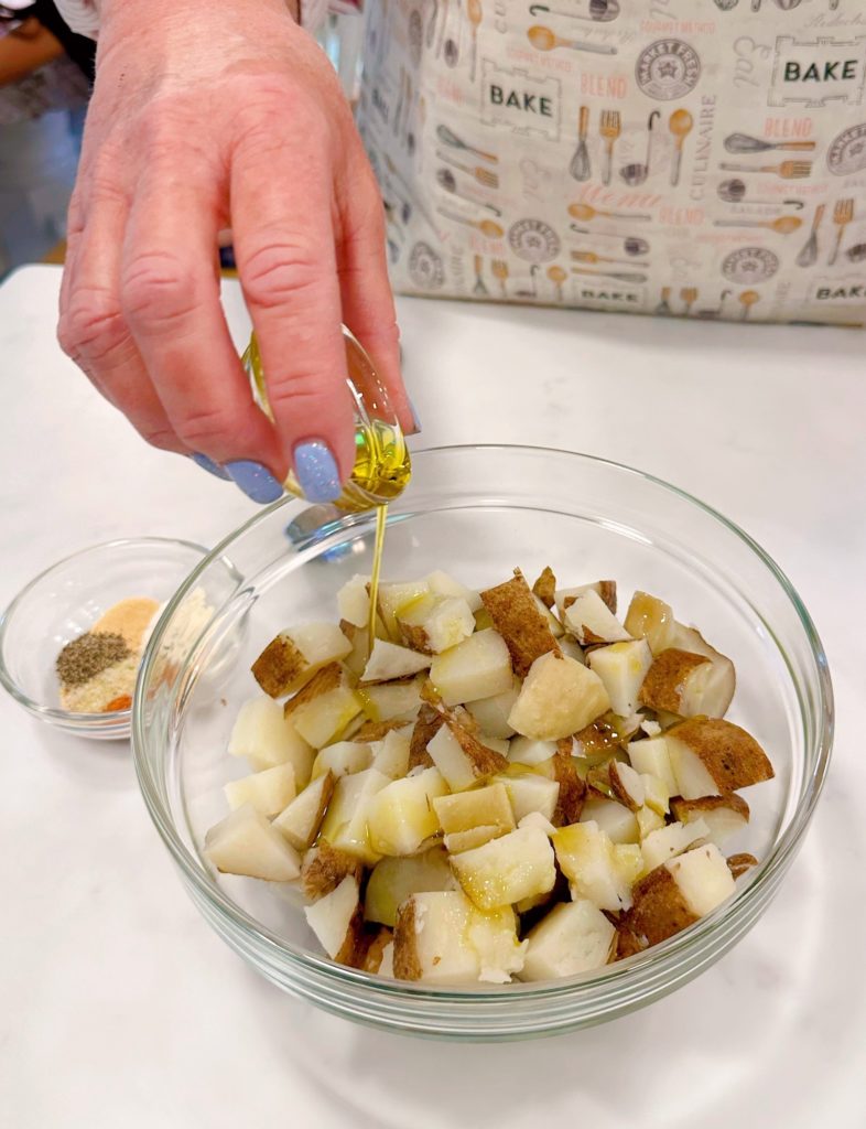 Potatoes in a bowl  adding olive oil.