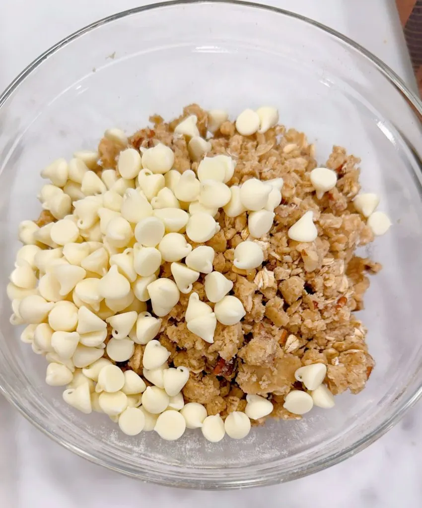 Oat crumb streusel topped with white chips in a bowl.