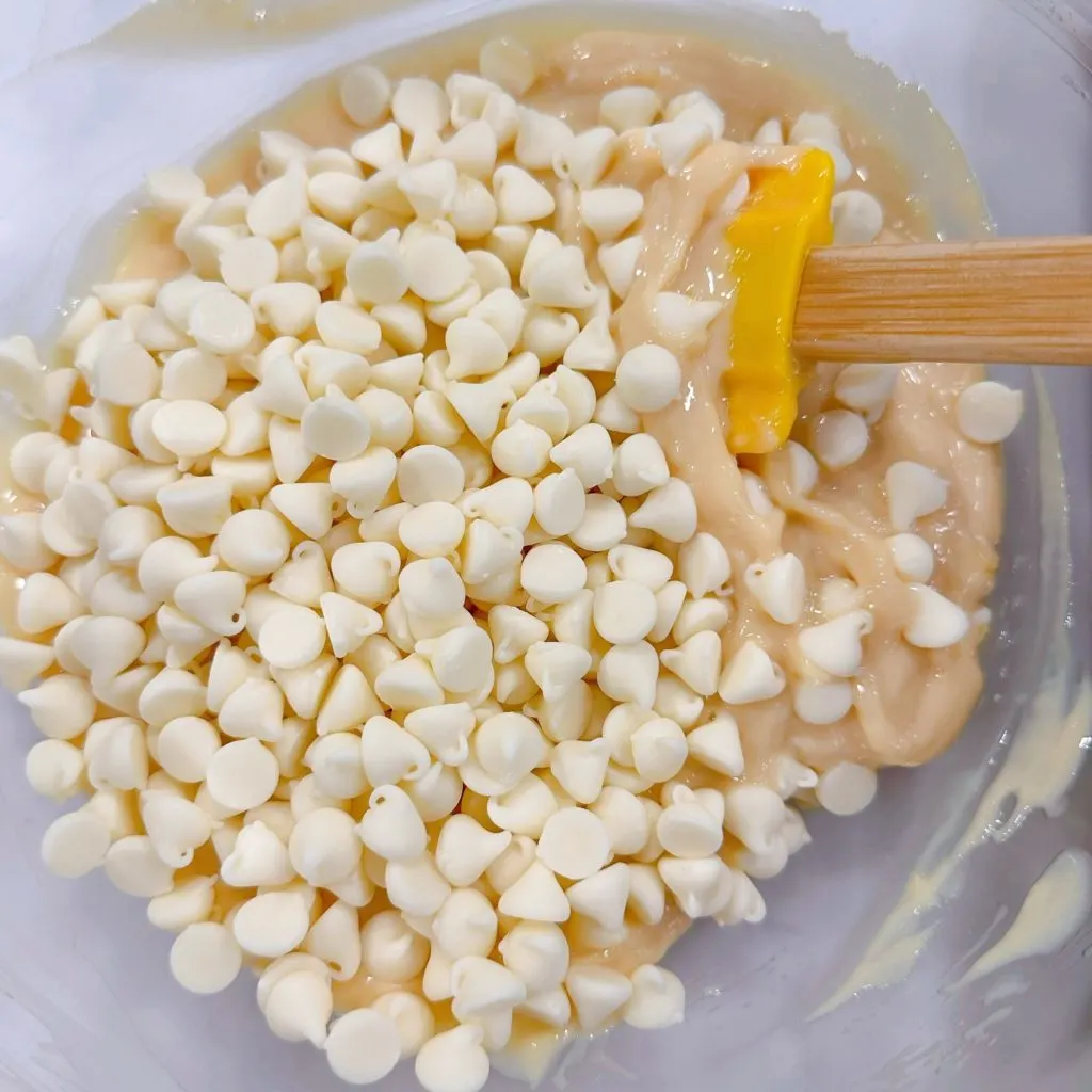 Adding white baking chips to the lemon filling mixture.