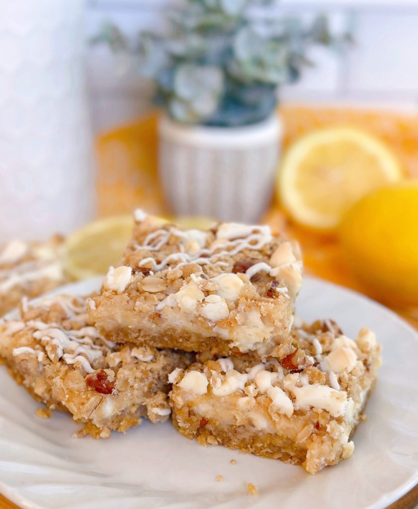 White Chip Lemon Streusel Bars stacked high on a white plate.