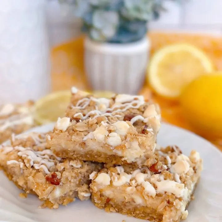 White Chip Lemon Streusel Bars stacked high on a white plate.