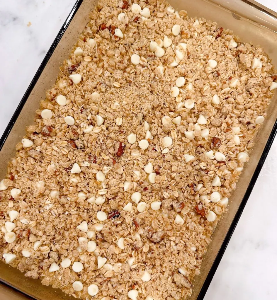 Baking pan filled with lemon bars and streusel topping ready to bake.