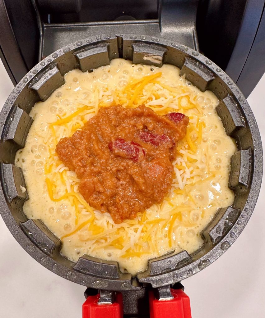 Chili on top of cheese in the cornbread waffle.