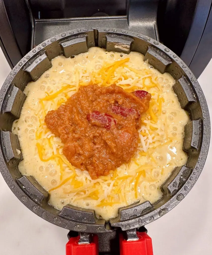 Chili on top of cheese in the cornbread waffle.