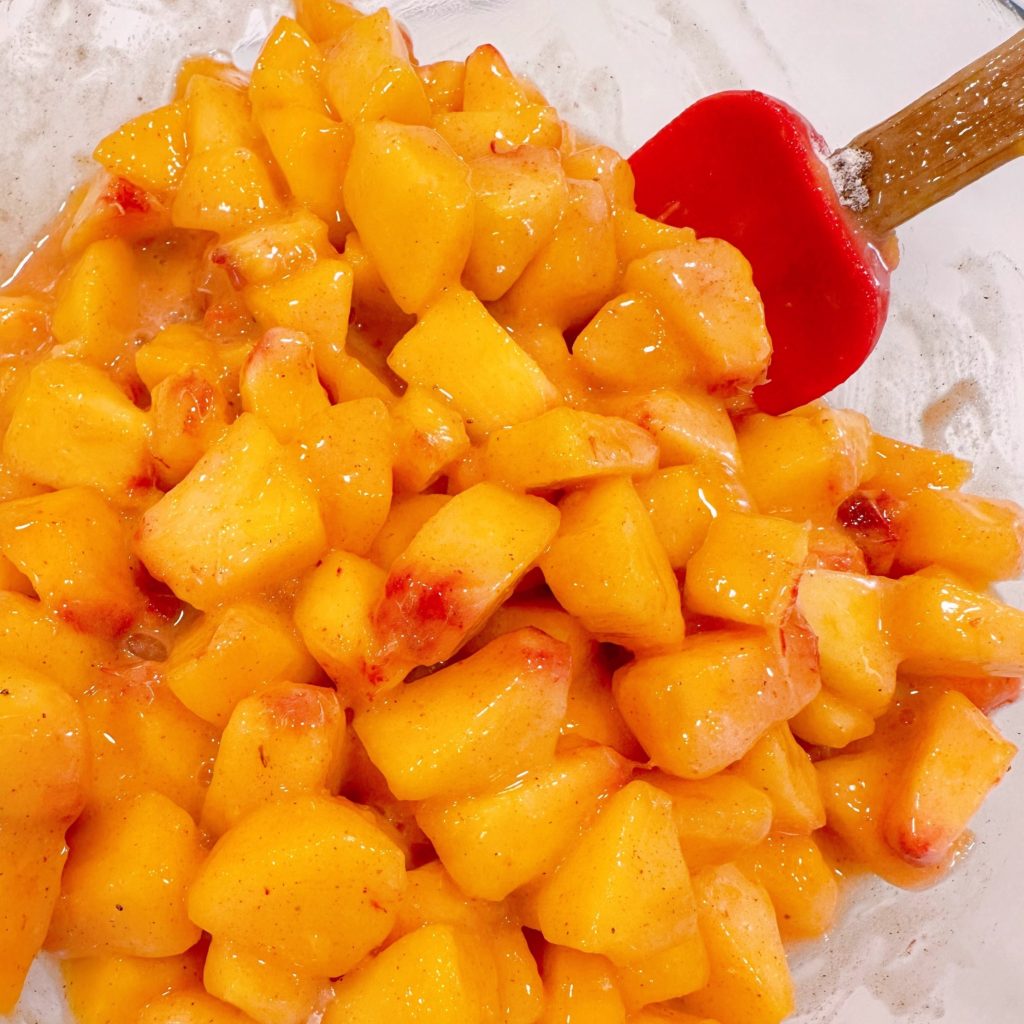 Peaches are mixed with sugar and spices.