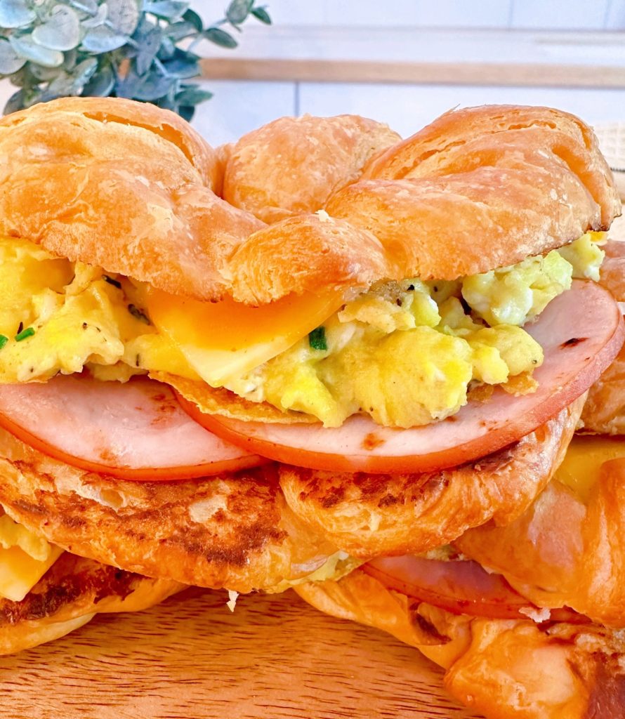 Close-up of egg croissant sandwich with cheese and canadian bacon.