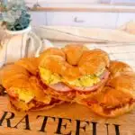 Stack of Croissant breakfast sandwiches with egg, bacon, and cheese.