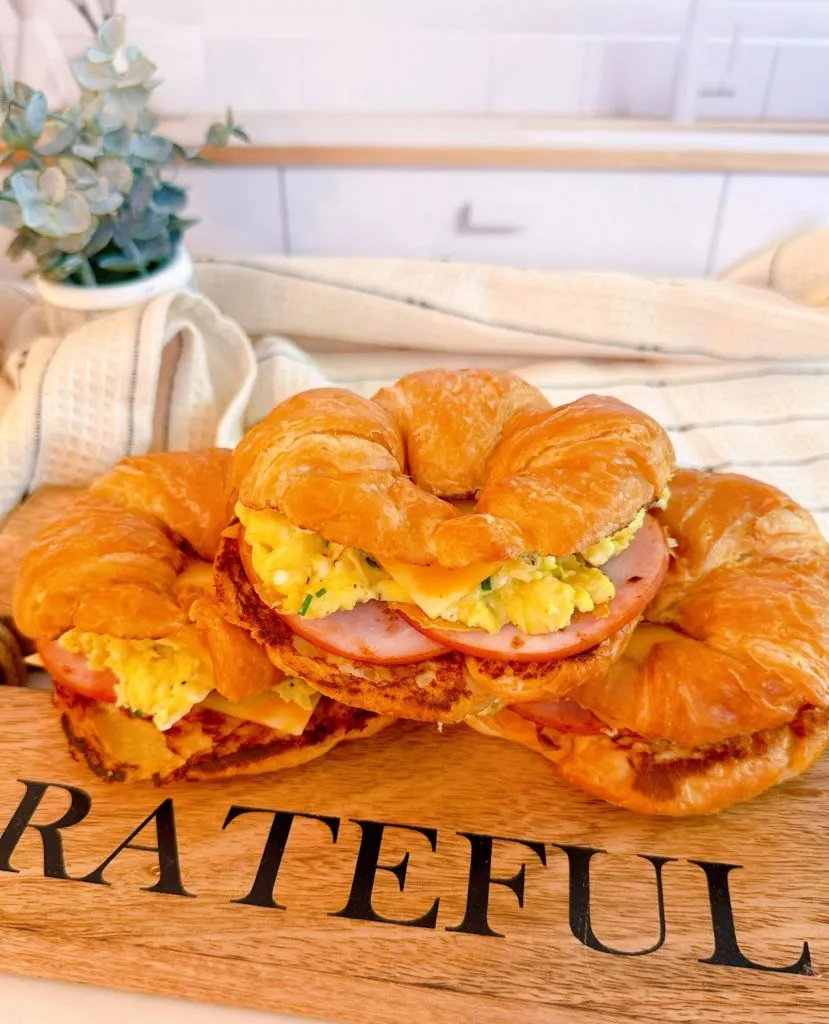 Stack of Croissant breakfast sandwiches with egg, bacon, and cheese.