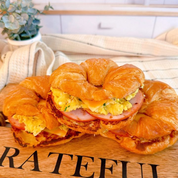 Stack of Croissant breakfast sandwiches with egg, bacon, and cheese.