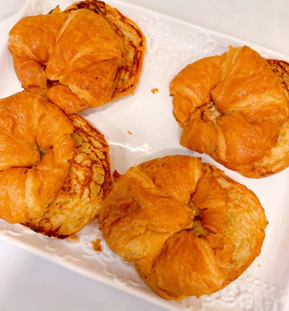 Toasted croissant buns on a platter.