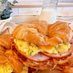 Easy breakfast croissants breakfast sandwiches stacked on a plate.