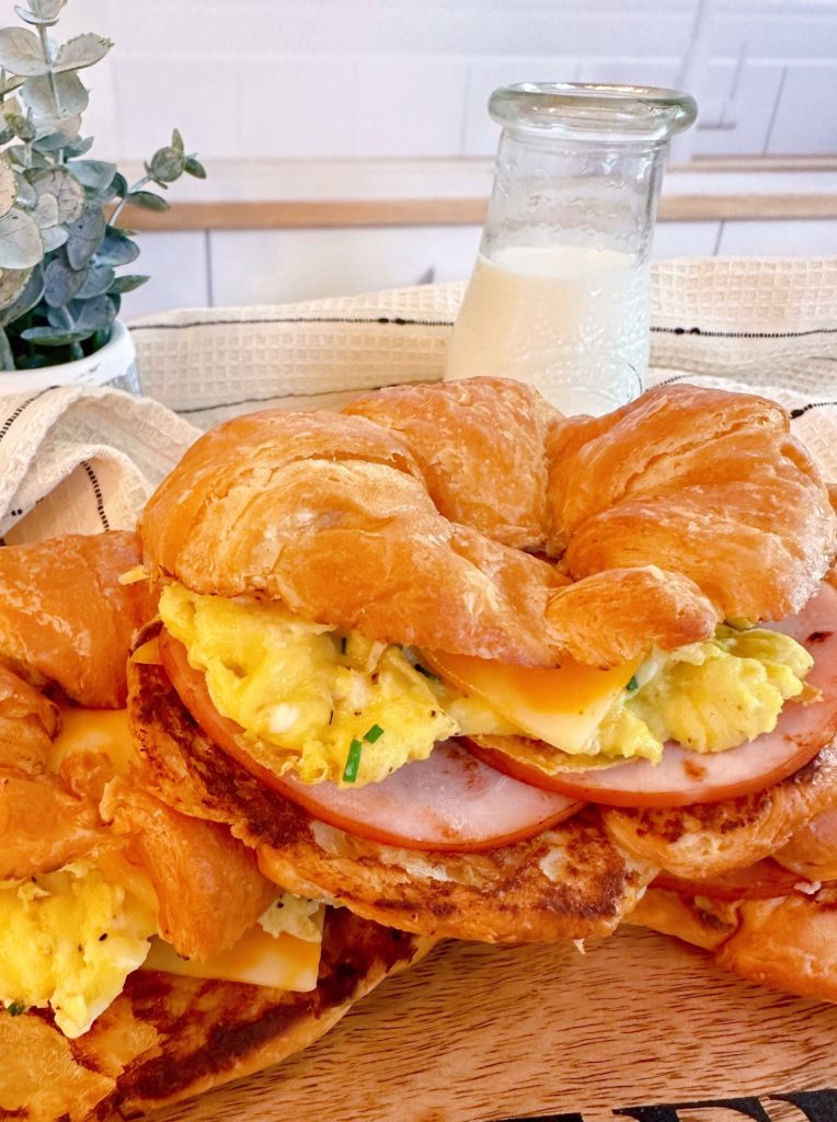 Easy breakfast croissants breakfast sandwiches stacked on a plate.