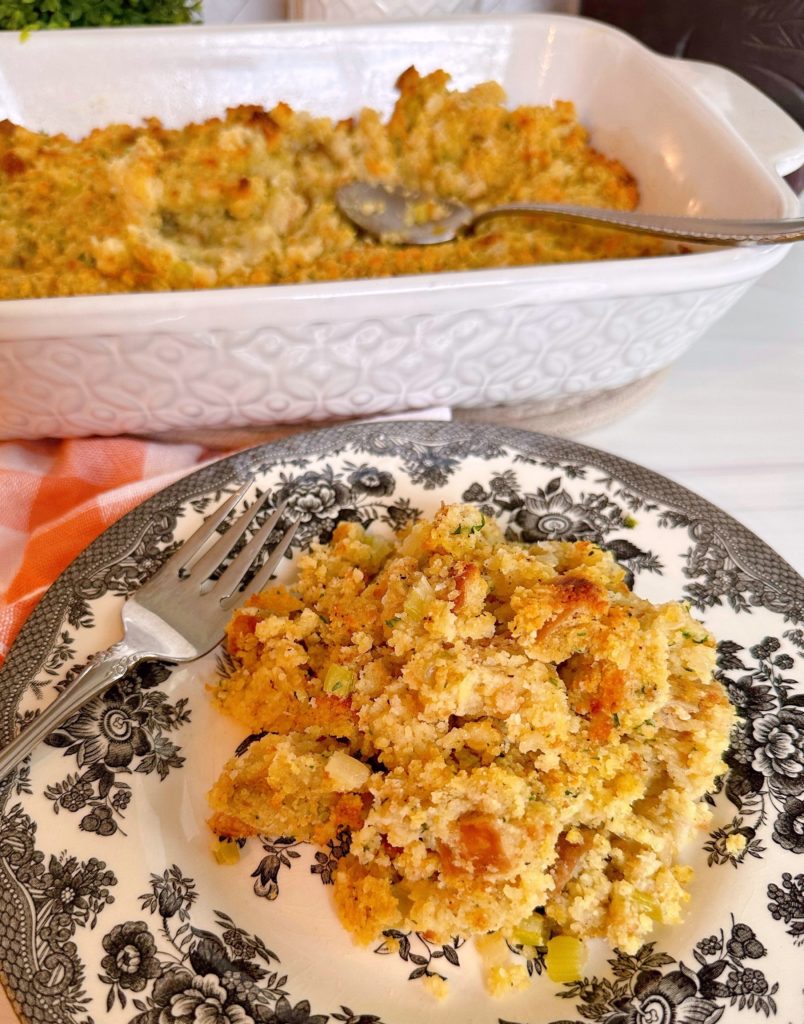 Easy Cornbread dressing on a plate with the casserole dish in the background.