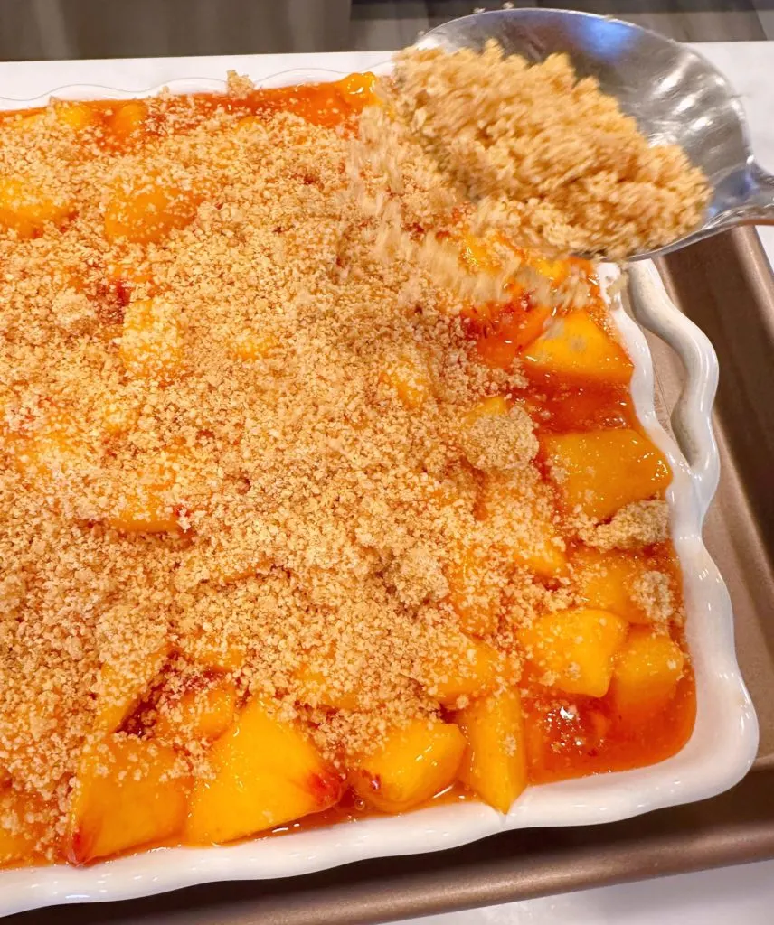 Graham crackers sprinkled on top of peaches layer.