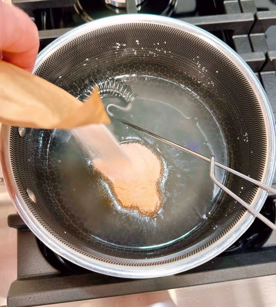 Adding package of orange jello to the thickened sugar mixture.