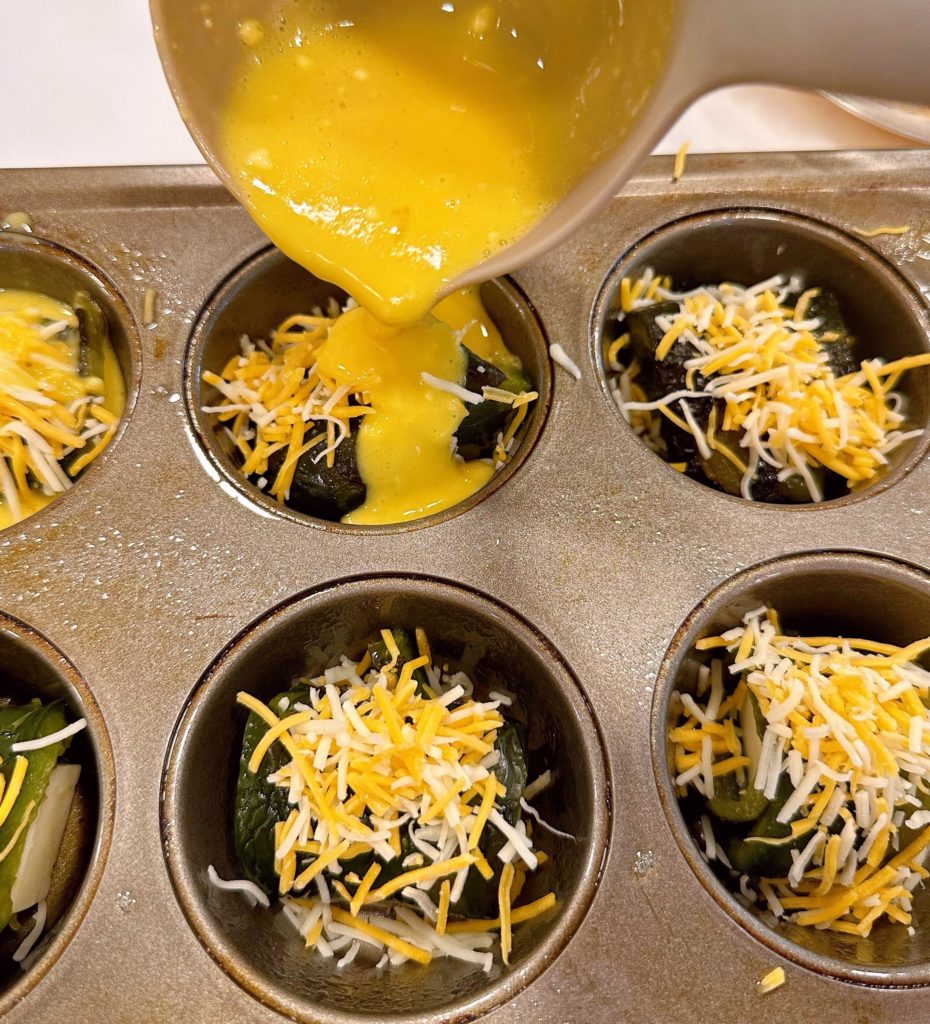 Pouring egg batter over stuffed peppers.