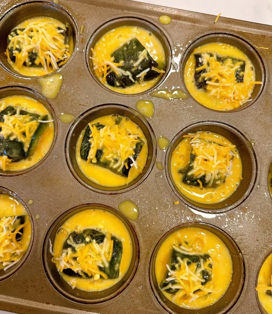 Egg batter over each stuffed pepper in the muffin tin.