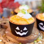 Chili Cornbread Cup filled with chili and topped with a cornbread muffin top, cheese, sour cream, and green onions in a fun Halloween ramakin.