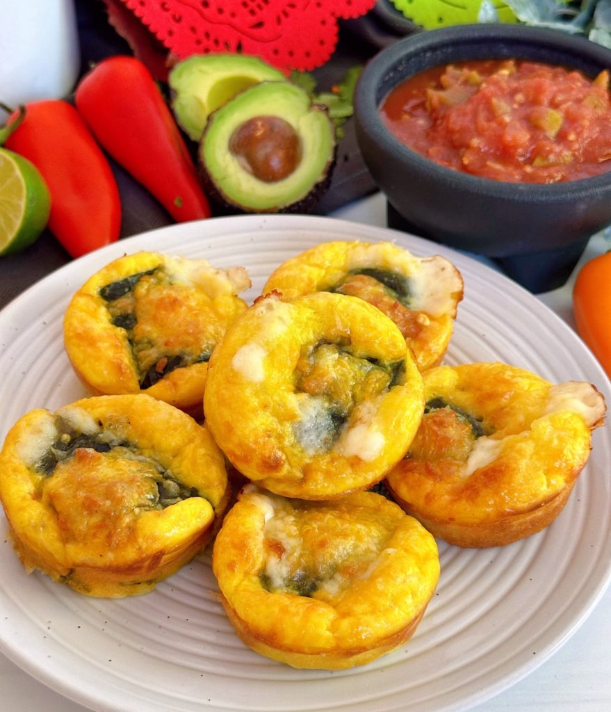 Chile Relleno Muffins stacked on a white plate with toppings in the back ground.