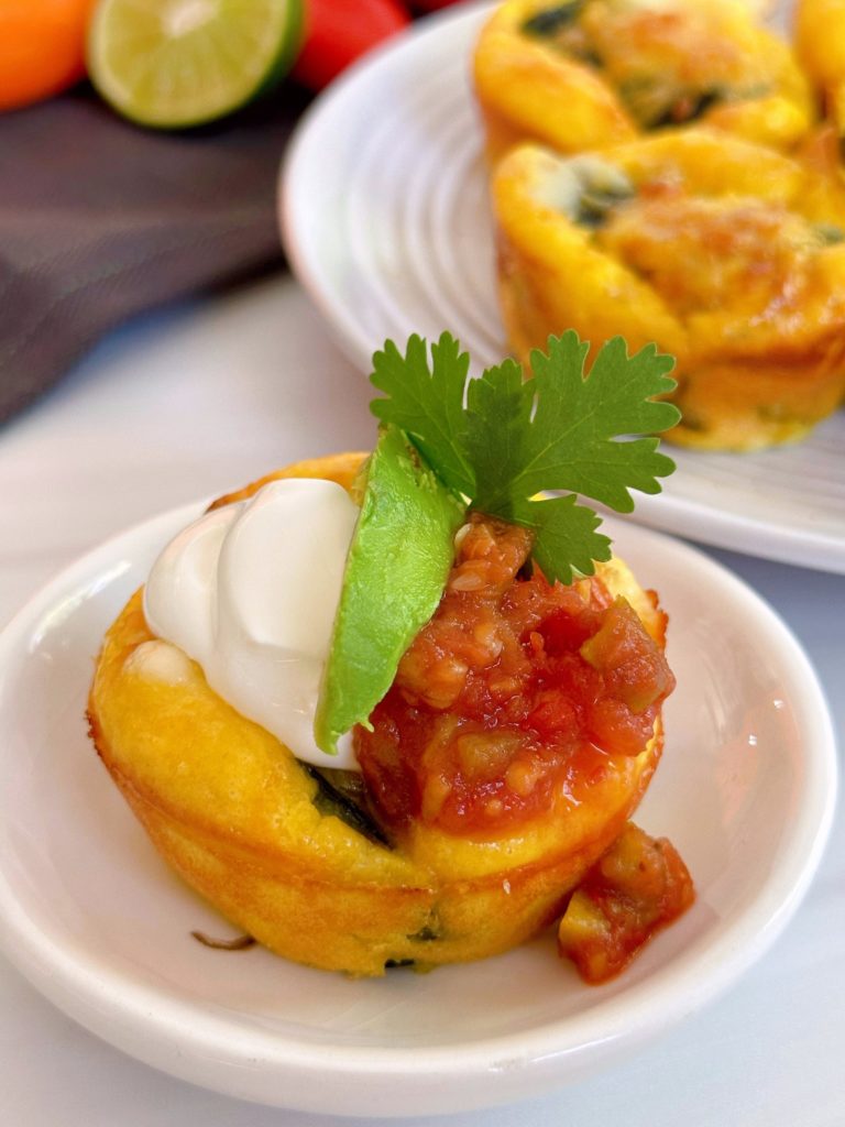 Chile Relleno Muffin topped with sour cream, salsa, and a wedge of avocado.