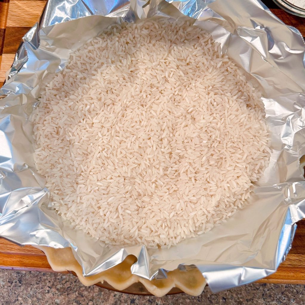 Pie crust lined with foil and uncooked rice.