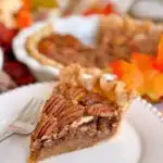 Slice of pecan pie on a dessert plate.