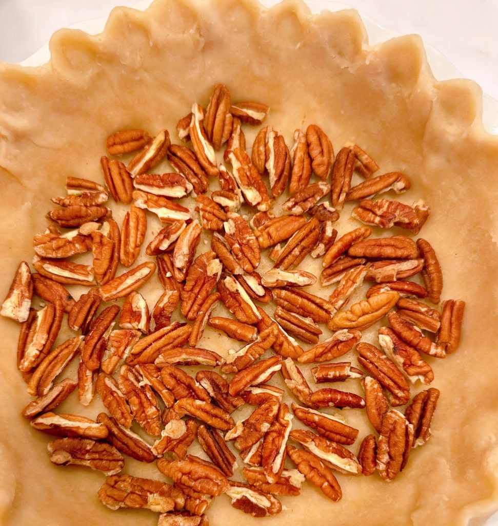 Pecan quarters arranged on the bottom of the pan.