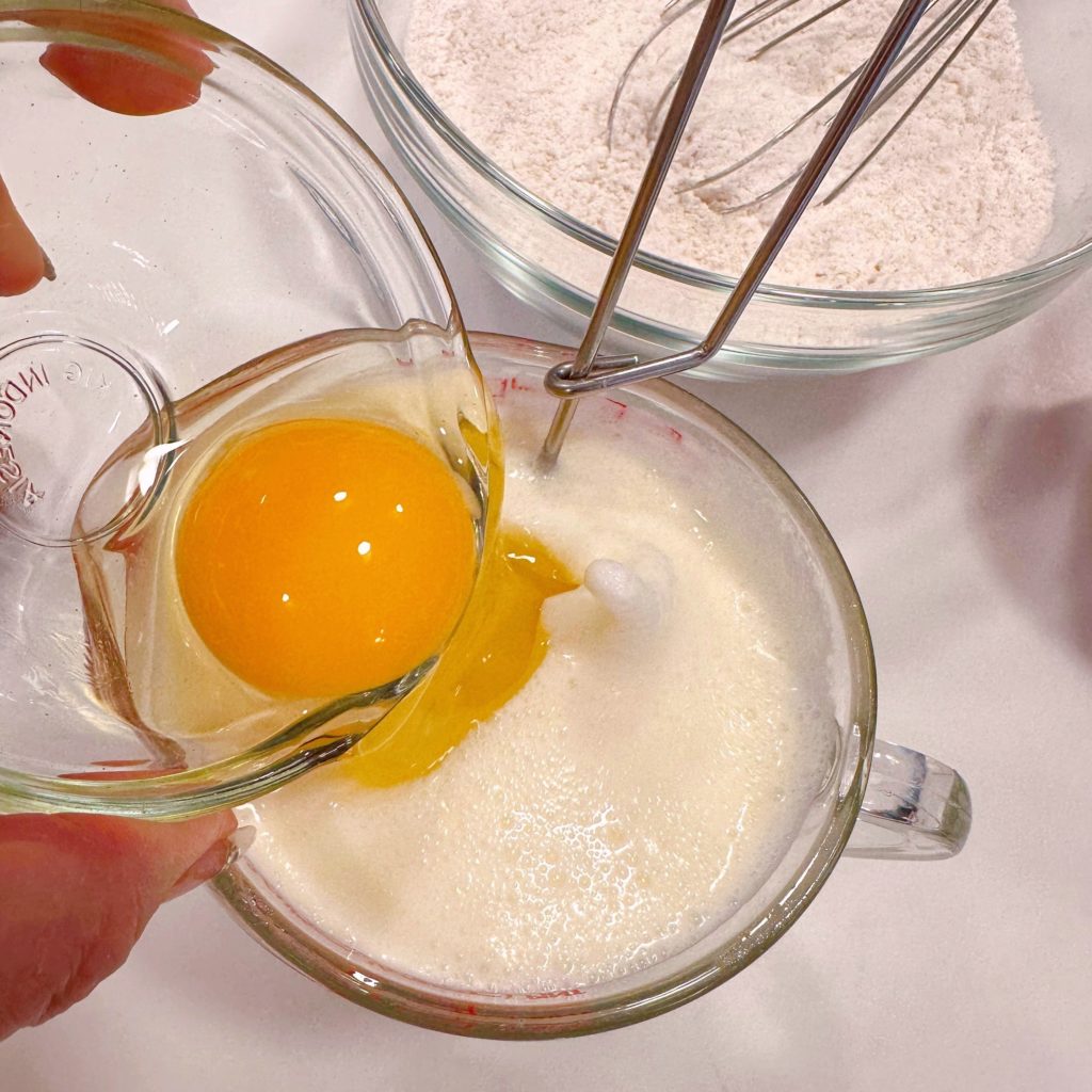 Adding eggs and milk to the wet ingredients.