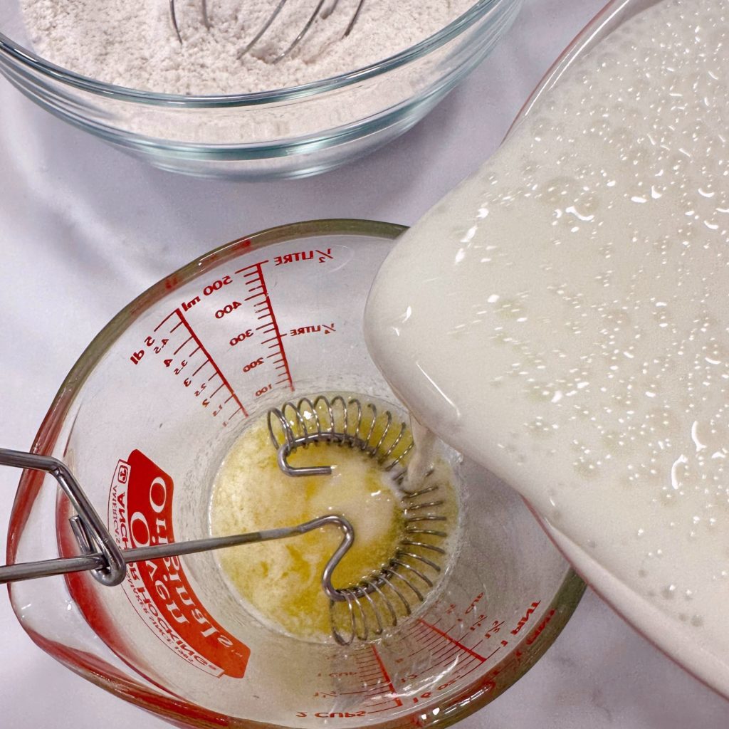 Whisking buttermilk into melted butter.