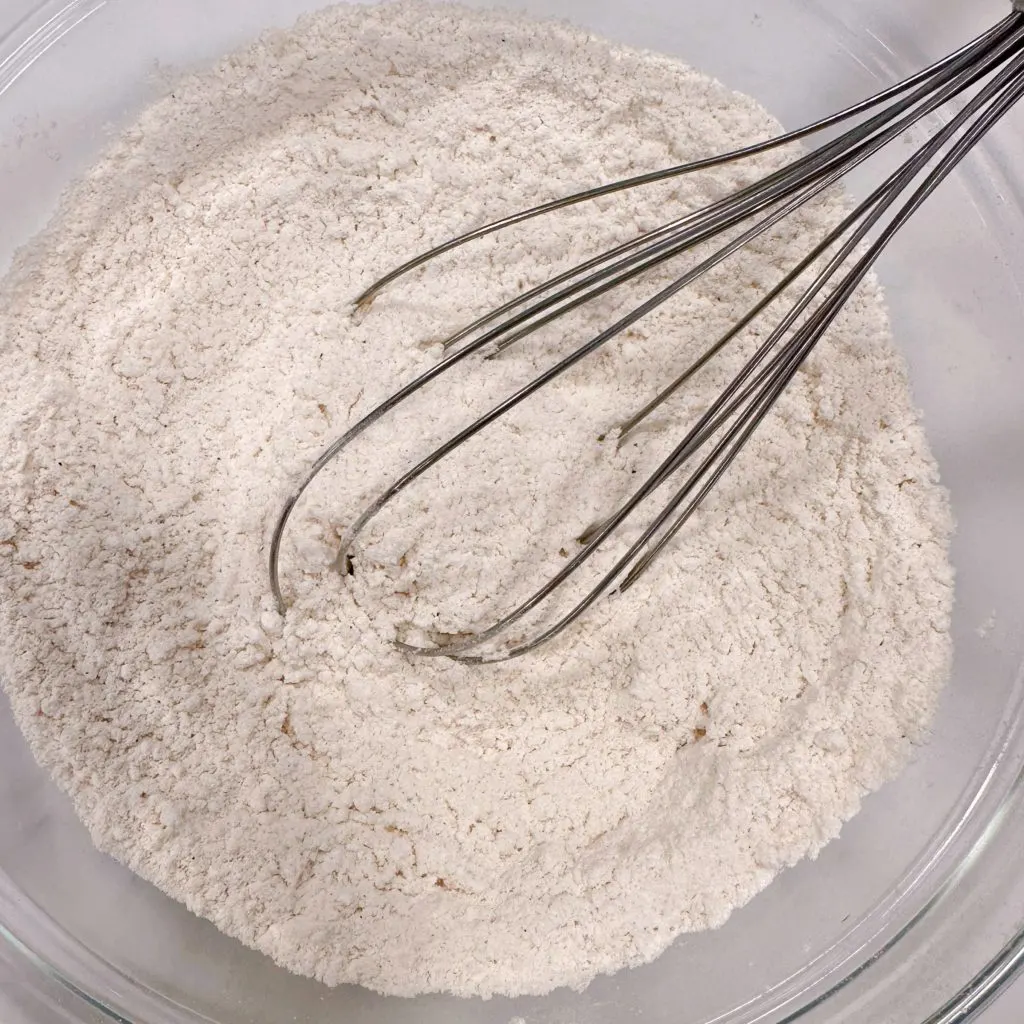 Whisking dry ingredients in a bowl.