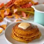 Stack of buttery pumpkin swirl pancakes with syrup.