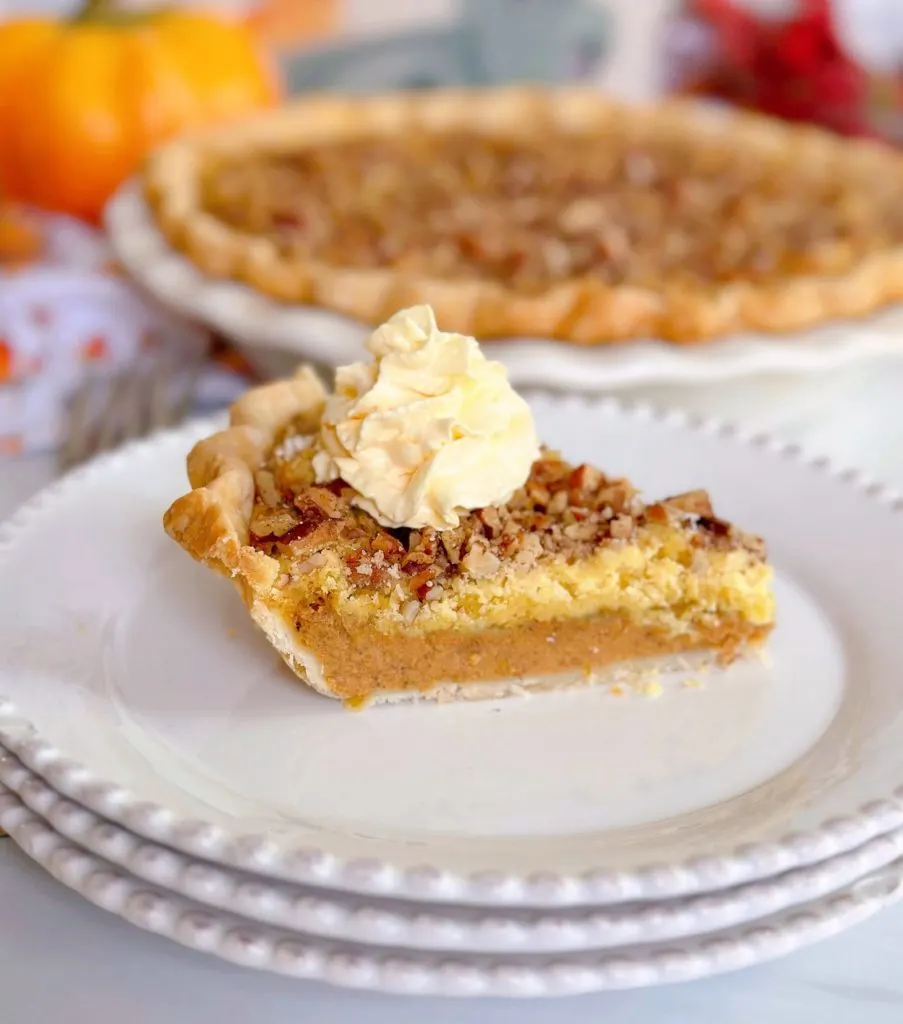 Slice of pumpkin crunch pie on a dessert plate with the rest of the pie in the background.