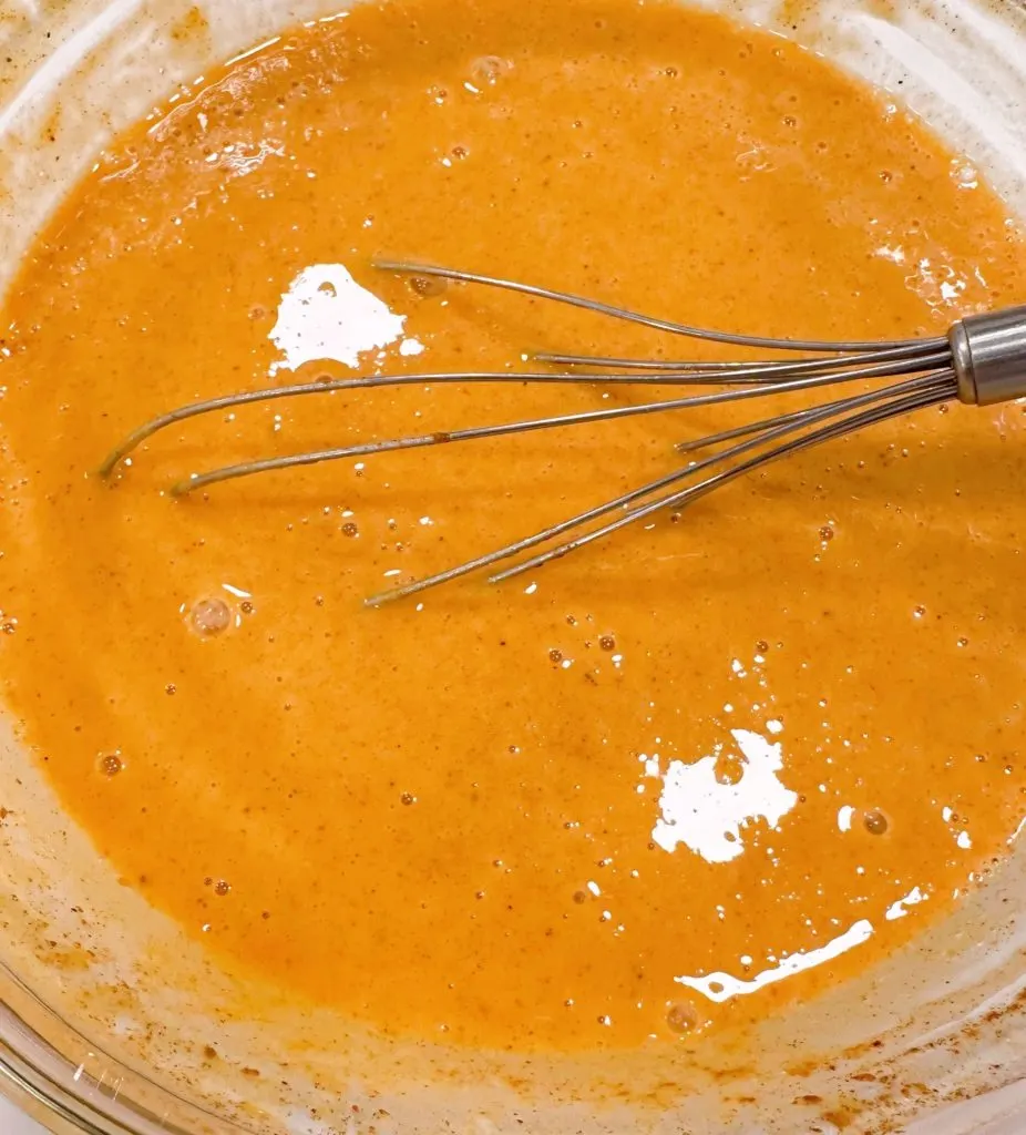 Pumpkin filling whipped with a wire whisk in a large bowl.