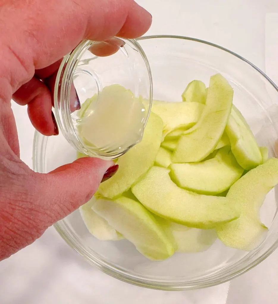 Tossing apple slices with lemon juice.