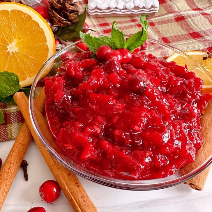 Cranberry Pear Chutney Recipe in a serving dish surrounded by spices.