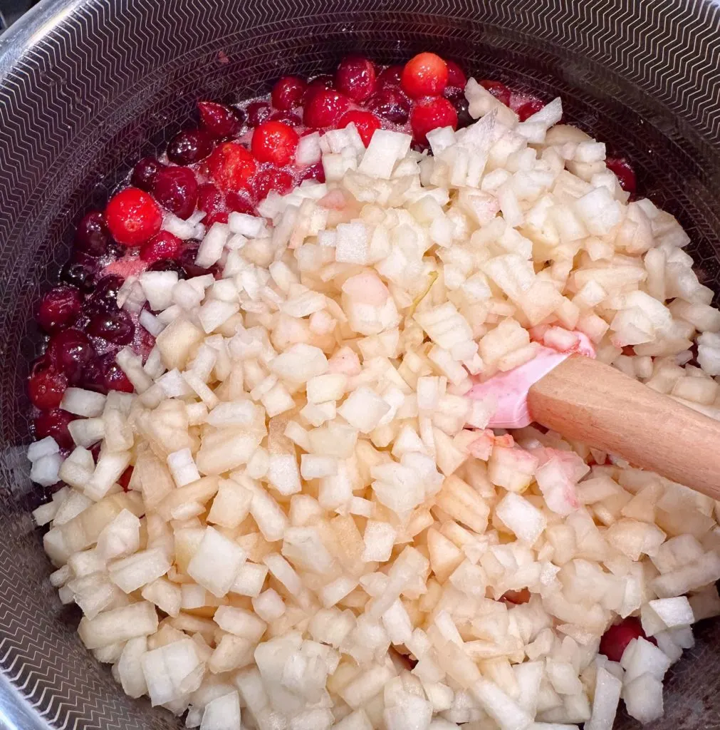 Diced pears are added to cranberries.