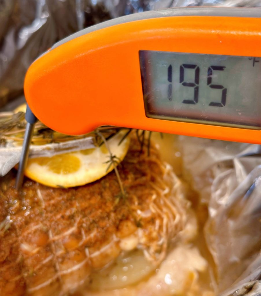 Meat thermometer checks the internal temperature of the turkey roast.