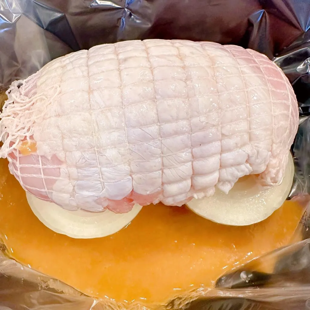 Turkey Roast on top of the onion halves in the bottom of the slow cooker liner in the slow cooker.