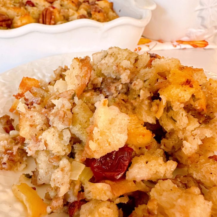 Baked stuffing on a serving plate with gravy.