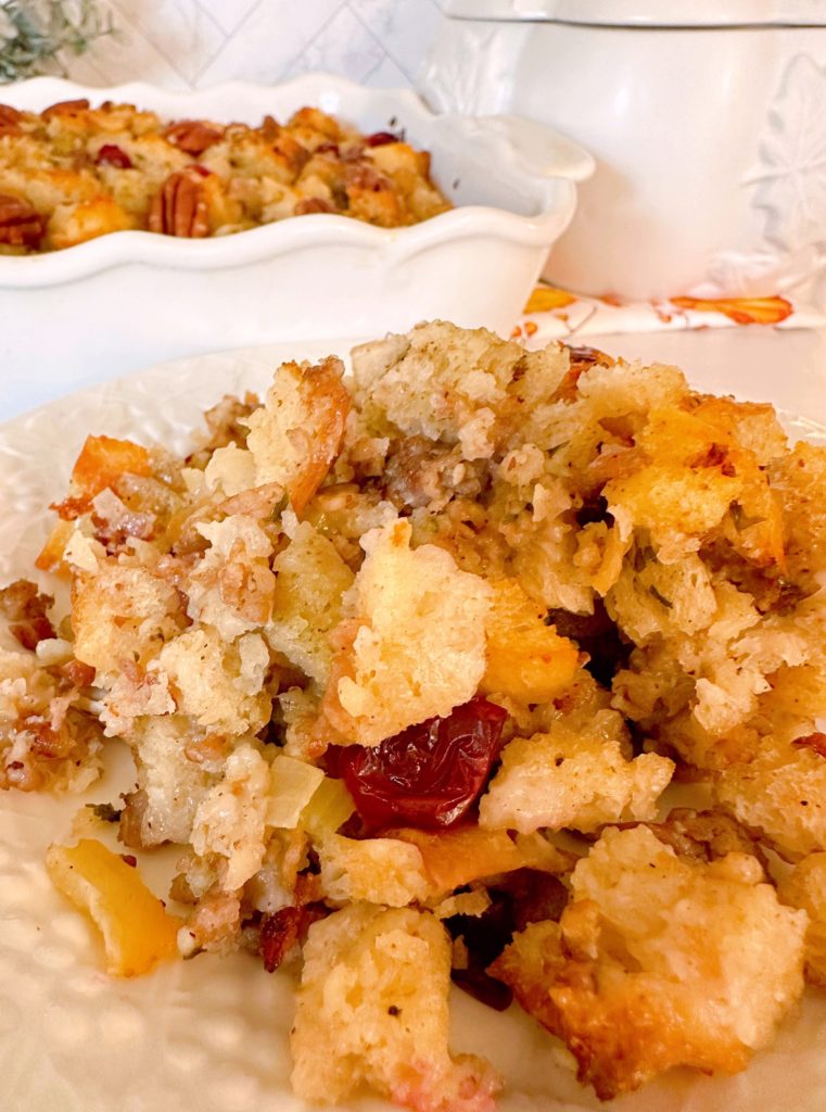 Baked stuffing on a serving plate with gravy.