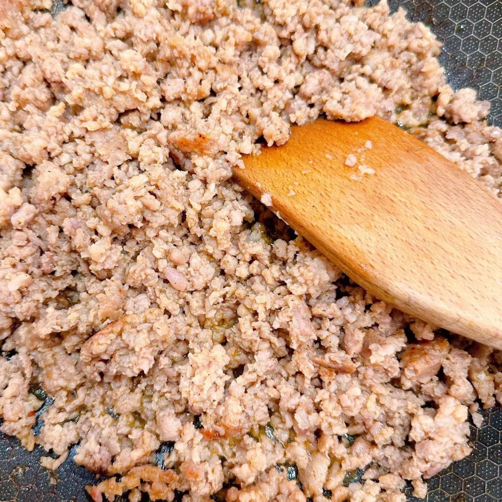 Browning the sausage in a large skillet on the stove top.