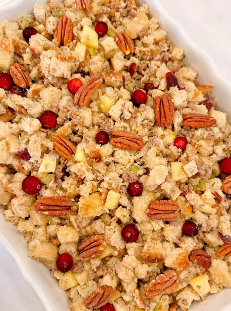 Spooned stuffing in large baking dish. Topped with pecan halves and fresh cranberries.