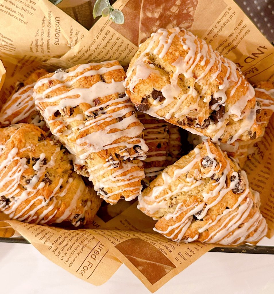 A dozen pecan chocolate chip scones in a basket.