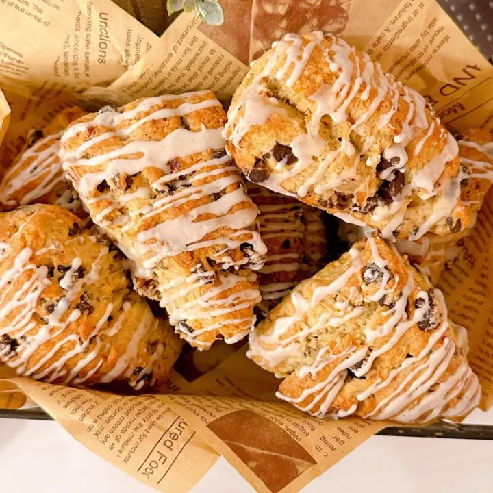 A dozen pecan chocolate chip scones in a basket.