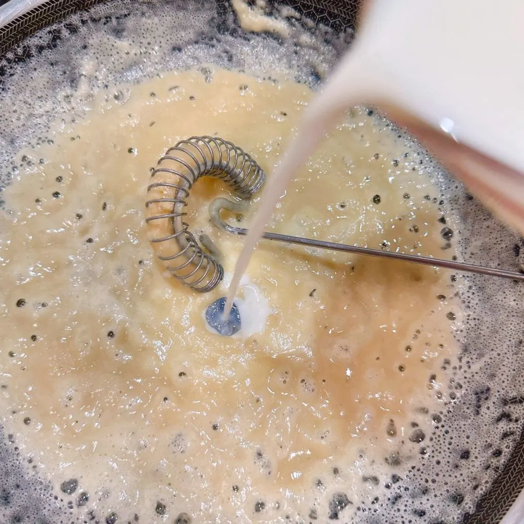 Adding milk to skillet mixture.