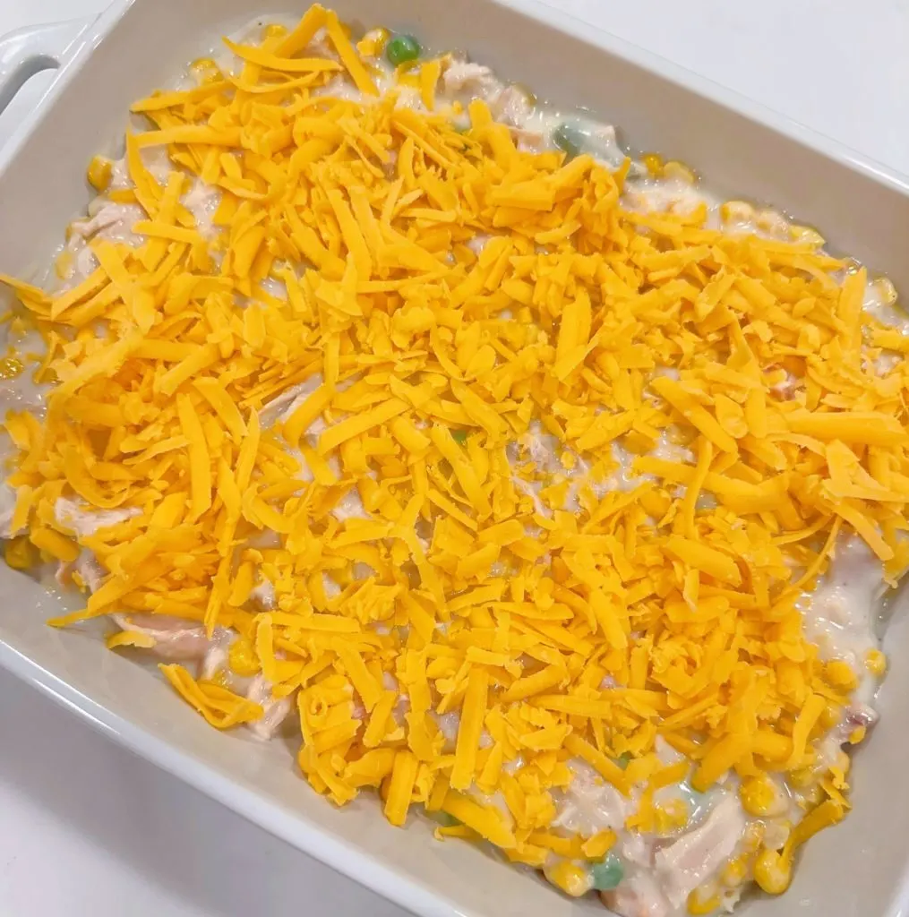 Adding cheese to the casserole.