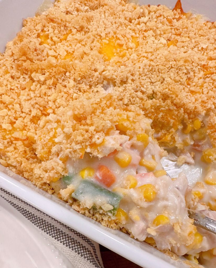 Casserole out of the oven, with a spoonful being lifted out of the dish.