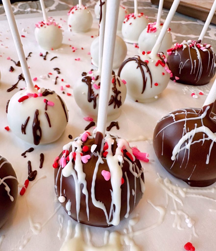 Cake balls on a parchment lined table.