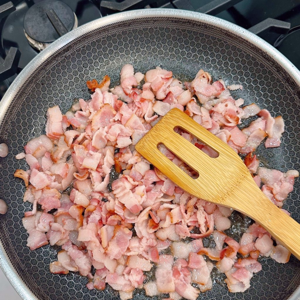 Cooking bacon bits on the stove top.